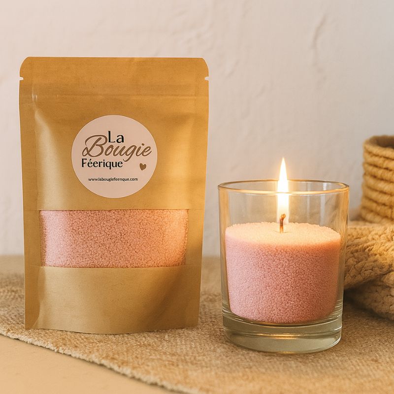 Perles de Cire Décorative pour Bougie, de couleur rose, avec son contenant transparent où il y a de la cire perle en démonstration, avec une mèche allumée. Ambiance scandinave.
