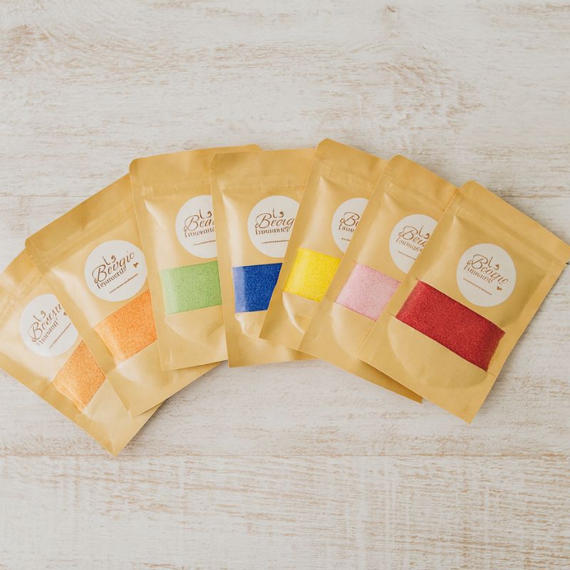 Perles de Cire Décorative pour Bougie, avec tous ses coloris disponible, blanc, vert, jaune, rose, rouge, bleu et orange. Fond gris clair.