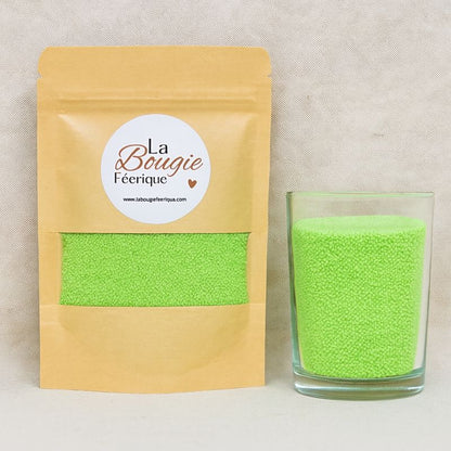 Recharge Bougie Cire Perle, de couleur verte, avec son contenant transparent où il y a de la cire perle en démonstration. Fond gris.