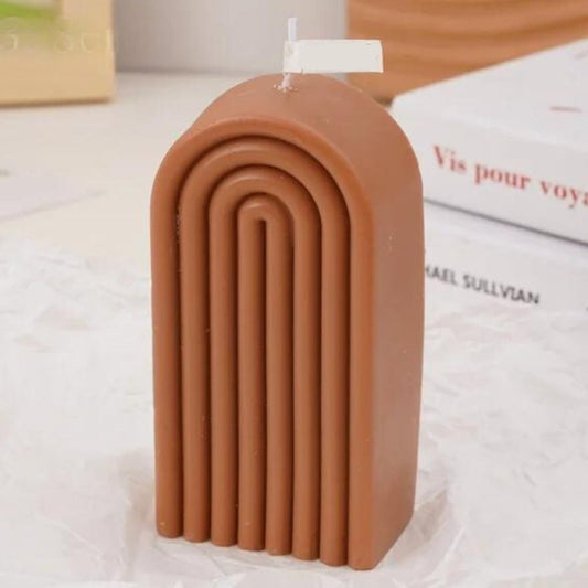 Bougie Décorative Arc Contemporain, de couleur marron, posée sur une table beige.