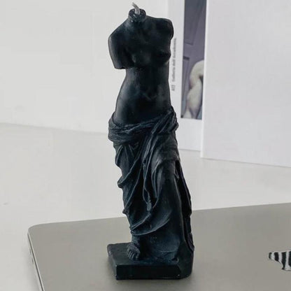 Bougie Décorative Statue, disposée sur une table grise et fond beige clair.